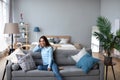 Happy woman resting comfortably sitting on sofa in the living room at home Royalty Free Stock Photo