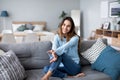 Happy woman resting comfortably sitting on sofa in the living room at home Royalty Free Stock Photo