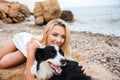 Happy woman resting and hugging her dog on the beach Royalty Free Stock Photo