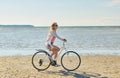 Happy woman riding bicycle along summer beach Royalty Free Stock Photo