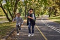 Happy woman riding on an e-scooter with her son. Young and beautiful caucasian woman rides electric scooter with boy in Royalty Free Stock Photo