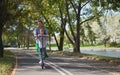 Happy woman riding on an e-scooter with her son. Young and beautiful caucasian woman rides electric scooter with boy in Royalty Free Stock Photo