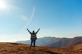 Happy woman rising hands up on top of autumn mountain. Beautiful view on autumn mountains. Travel, freedom and happiness, Royalty Free Stock Photo