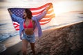 Happy woman running on beach while celebrateing independence day and enjoying freedom in USA Royalty Free Stock Photo