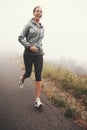 Happy, woman and running on road outdoor in forest, park or woods for exercise in winter. Morning, fog and person with Royalty Free Stock Photo