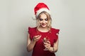 Happy woman in Santa hat holding glass of wine with red Christmas decoration on white background Royalty Free Stock Photo