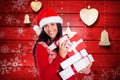 Happy woman in santa hat holding stack of christmas gifts Royalty Free Stock Photo
