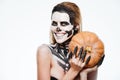 Happy woman with scared halloween makeup holding pumpkin and smiling