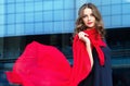 Happy woman with a scarf. Portrait of the beautiful girl.Fashionable portrait of a girl model with waving red silk scarf. Royalty Free Stock Photo