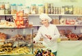 Happy woman seller offering sweets