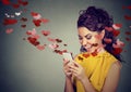 Happy woman sending love text message on mobile phone Royalty Free Stock Photo