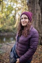 Happy woman with a serene smile standing in the forest