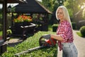 Happy woman shaping bushes with electric trimmer Royalty Free Stock Photo