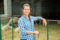 Happy woman sheep breeder in stall