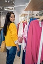 Happy woman shopaholic looking label price on pink dress at store boutique enjoying sale discount Royalty Free Stock Photo