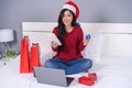 happy woman shopping online for Christmas gift with digital tablet and credit card on bed Royalty Free Stock Photo