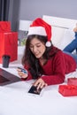 happy woman shopping online for Christmas gift with digital tablet and credit card on bed Royalty Free Stock Photo