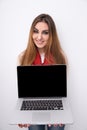 Happy woman showing blank laptop screen