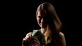 Happy woman showing euros banknotes against black background, casino jackpot
