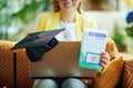 Happy woman showing graduation cap, laptop and textbook