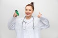 Happy woman showing thumb up and holding bottle with pills Royalty Free Stock Photo