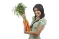 Happy woman shows on a bunch of carrots Royalty Free Stock Photo