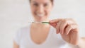 Happy woman shows a positive pregnancy test. The concept of female fertility. Human chorionic gonadotropin. Two stripes