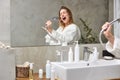 happy woman singing in bathtub using shower head having fun alone, after shower Royalty Free Stock Photo