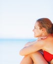 Happy woman sitting on beach and looking on copy space Royalty Free Stock Photo