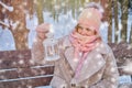 A happy woman is sitting on a bench with a lantern in her hands, a wint Royalty Free Stock Photo