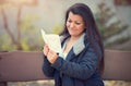 Happy woman sitting on a bench and reading a love letter Royalty Free Stock Photo