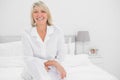 Happy woman sitting cross legged in her bedroom Royalty Free Stock Photo