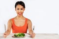 Happy Woman Sitting In Front Of Lettuce Leaves On Plate Royalty Free Stock Photo