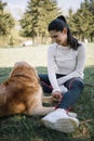 Happy woman sitting on ground in nature with her dog