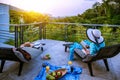 A happy woman sitting reading relaxing book on the balcony at home, summer on holiday drinking wine,orange juice and fruit on the Royalty Free Stock Photo