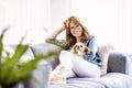 Happy woman sitting on the sofa with her small dog Royalty Free Stock Photo