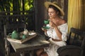 Happy woman sitting on the summer terrace and drinking coffee Royalty Free Stock Photo