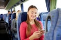 Happy woman sitting in travel bus with smartphone Royalty Free Stock Photo