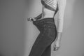 Happy woman. Slim waist of young female in big jeans