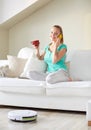 Happy woman with smartphone drinking tea at home