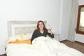 Happy woman smiling on bed with thumb up .