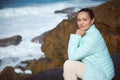 Happy woman smiling at camera, sitting on the cliff and enjoying beautiful view of Atlantic ocean. People. Tour tourism.