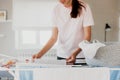 Happy woman smiling, hanging clean wet clothes laundry on drying rack at home Royalty Free Stock Photo