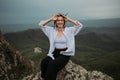 Happy woman smiling tourist hiking up mountain enjoying nature. Landscape in cloudy gloomy windy weather. Female in