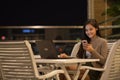 Happy Woman Smiling And Using Mobile Phone And Laptop Computer Outdoors At Night Royalty Free Stock Photo