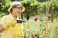 Happy woman spraying roses