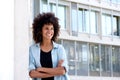 Happy woman standing with arms crossed by urban building Royalty Free Stock Photo