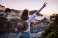 Happy woman standing on cliff over Mediterranean sea bay and showing peace sign. Lady enjoying freedom, summer vacation Royalty Free Stock Photo