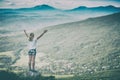 Happy woman standing on a cliffs edge. Instagram stylization