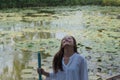 Woman standing in front of lotus flowers pond